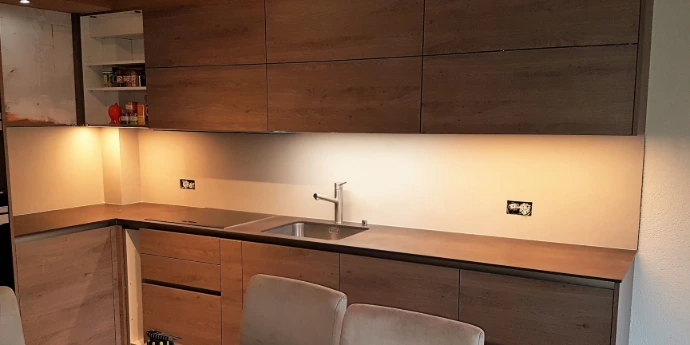 Rénovation de cuisine à Nendaz par Céramique XXL : pose d'un plan de travail sombre et d'un carrelage mural élégant.